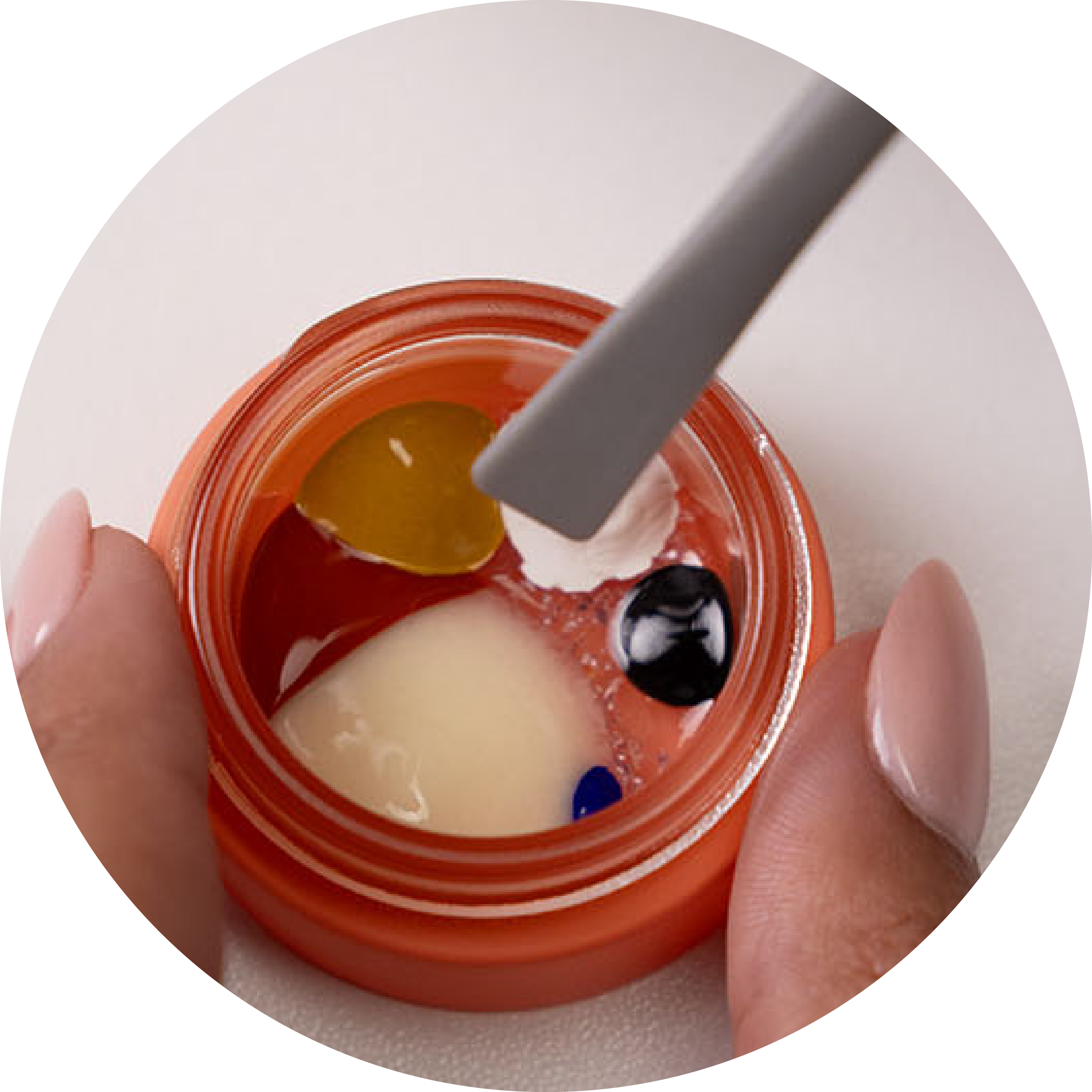 a jar of unmixed boldhue foundation pigments in the colors of white, black, blue, yellow, red and the base foundation