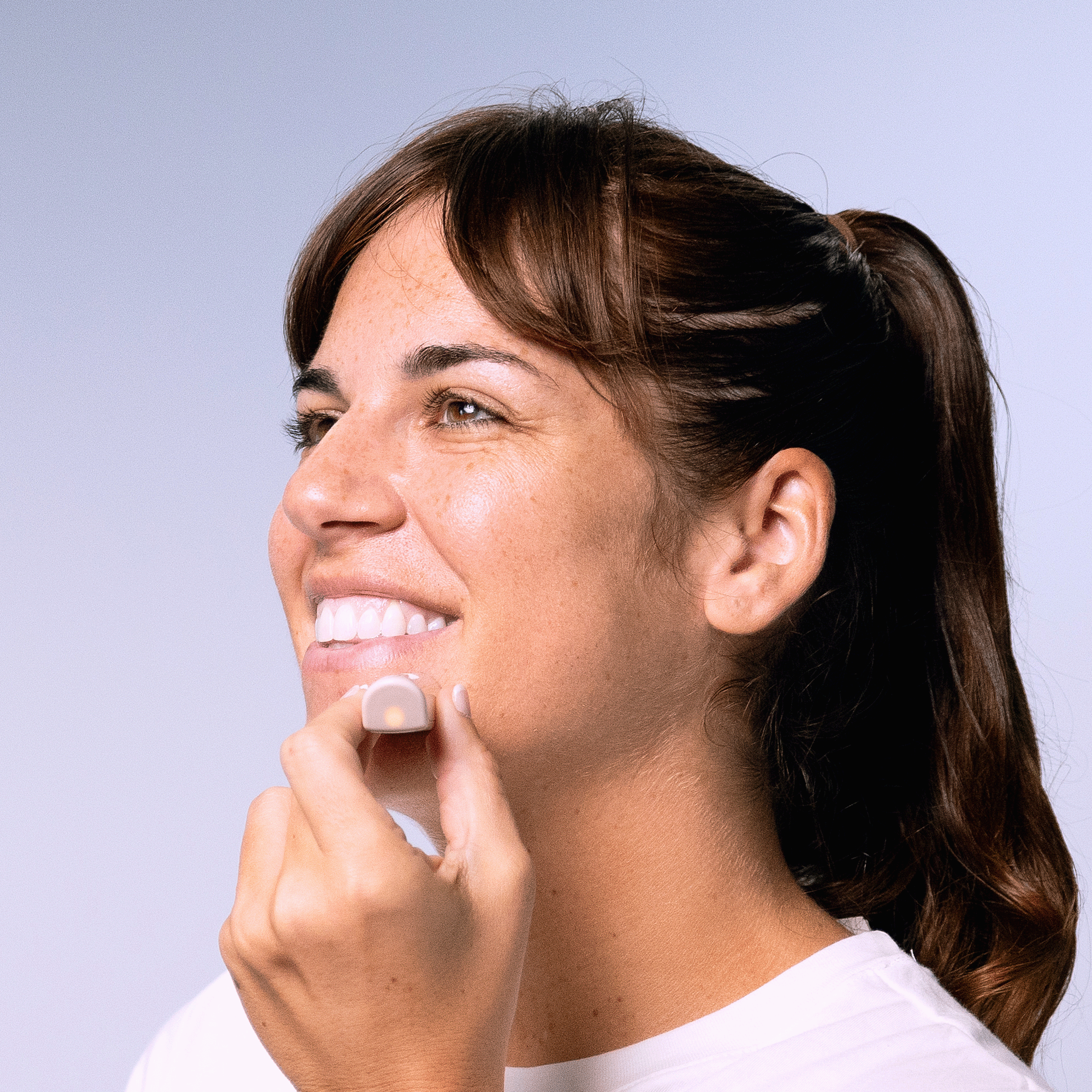 a picture of a female model scanning her chin using the boldhue wand